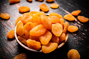Full wooden plate with dried apricots. 