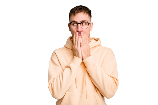 Young caucasian man cut out isolated thoughtful looking to a copy space covering mouth with hand.