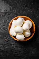 Mozzarella cheese in a wooden plate on the table. 