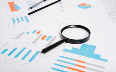Fototapeta premium Workplace low angle view, Close-up of financial business documents, magnifier, pencil and pen on desktop, selective focus