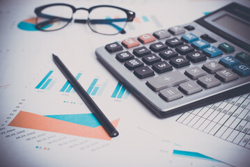 Accounting and financial concept. Close-up calculator, business documents, pencil glasses at workplace. Low angle view, selective focus