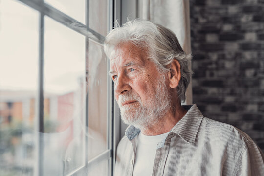 Pensive Elderly Mature Senior Man In Eyeglasses Looking In Distance Out Of Window, Thinking Of Personal Problems. Lost In Thoughts Elderly Middle Aged Grandfather Suffering From Loneliness, Copy Space