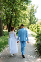 Fototapeta premium bride in a light wedding dress to the groom in a blue suit