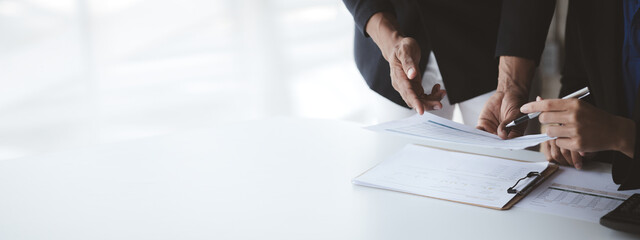 Two businessmen pointed to the material for the meeting, working together to plan to develop and solve common business problems. Concept of business management for growth and quality.
