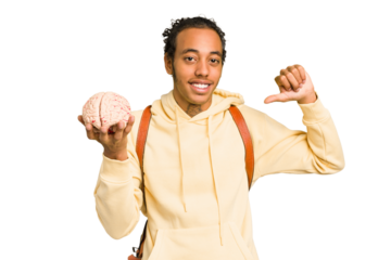 Young African American man holding a brain isolated feels proud and self confident, example to follow.