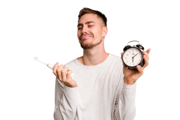 Young man holding an electric brush and an alarm clock cut out isolated