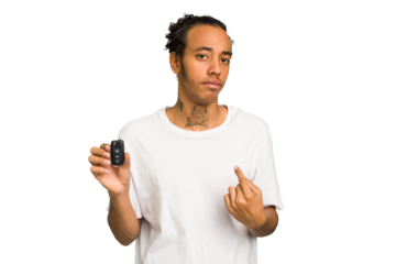 Young African American man holding car keys isolated pointing with finger at you as if inviting come closer.