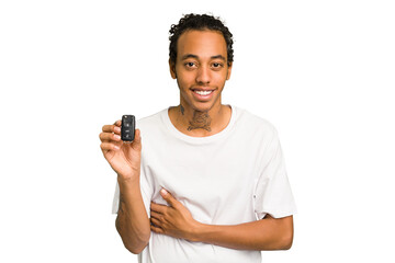 Young African American man holding car keys isolated laughing and having fun.