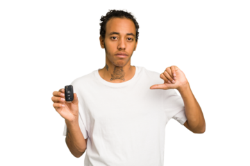 Young African American man holding car keys isolated showing a dislike gesture, thumbs down. Disagreement concept.