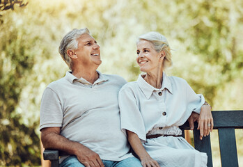 Love, retirement and couple on bench in park with smile, relax and bonding time in nature together....