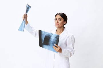 Woman doctor holding X-ray in robe on white background, consequences of covid-19, pneumonia and lung damage, concept of health 