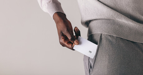 Professional man with a premium bank account puts his credit card into his pocket