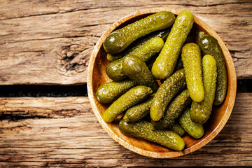 Pickled cucumbers on a wooden plate. 