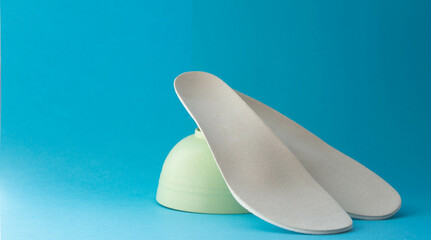 Leather orthopedic insoles on blue background. Prevention and treatment of flat feet. Foot care.