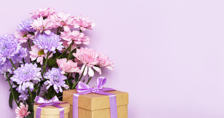 Greeting card for happy birthday, women's day on March 8, valentines day, mother's day or anniversary. Bouquet of delicate fresh flowers and two gifts in boxes on pink background. Empty space for text