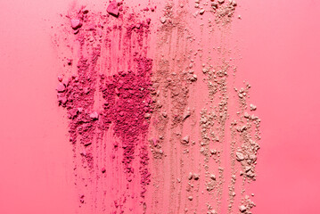 Abstract composition made from crushed face powder and blush on pink background