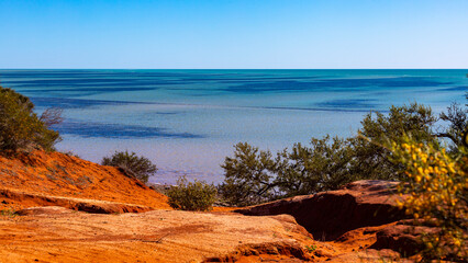 Fototapeta na wymiar panorama of shark bay in francois peron national park near monkey mia in western australia; red cliffs over the ocean in the australian outback
