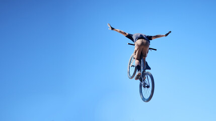 Fitness, bicycle and man doing a trick in the sky for a competition, exercise or training. Sports, cycle and male athlete or cyclist doing a stunt with skill for outdoor workout or contest with bike.