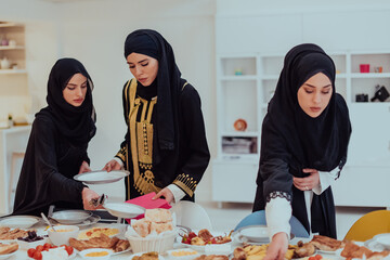 Eid Mubarak Muslim family having Iftar dinner young muslim girls serving food on the table during...