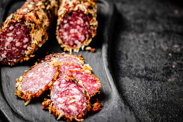Sliced salami sausage. On a black background.
