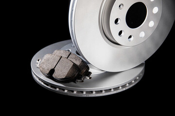 Automotive spare parts from the braking system. Brake pads and discs on a black background, close-up