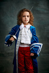 Cinematic portair of beautiful little girl dressed up as medieval knight, little prince over dark vintage style background, Fashion, beauty, emotions, theater concept