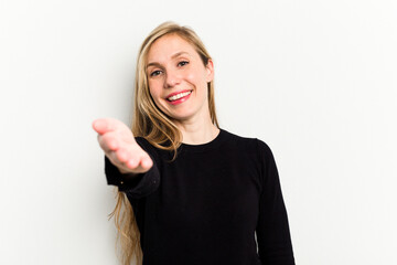 Young caucasian woman isolated on white background stretching hand at camera in greeting gesture.