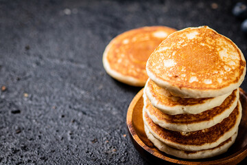 A pile of homemade pancakes in a plate on the table. 