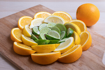 Citrus wedges arranged in a circle with a whole orange sitting on the side.