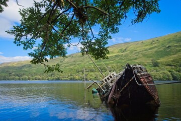 Wreck of a fishing boat on the shallows of Loch Oich near the ruins of Invergarry Castle - 563905701