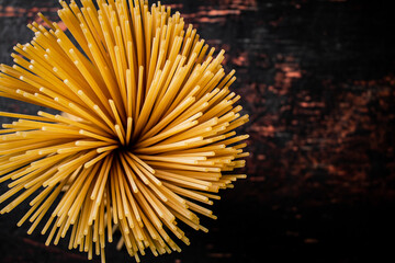 Not cooked spaghetti dry. Against a dark background.