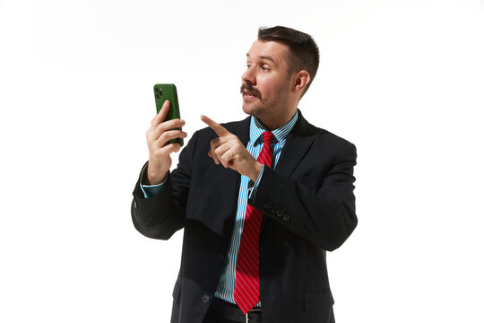 Businessman in a suit looking on phone over white studio background. Online work, communication. Concept of business, career, innovations, ad