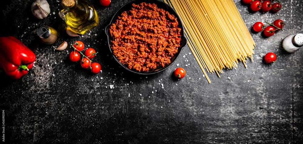 Wall mural bolognese sauce in a pan with tomatoes, and pasta dry.