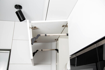 The modern lifting mechanism of a facade of a door with the closer. Furniture kitchen fittings