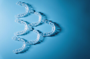Invisible orthodontics, a lot of plastic braces on a blue background. No people