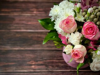 Vintage wooden surface, A beautiful bouquet with different flowers in a round box on a wooden brown textured background. Concept of greeting or invitation card. Thank you card, copy space