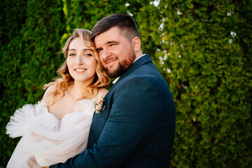 portrait of lovers and happy bride and groom against the backdrop of green trees