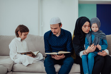 Happy Muslim family enjoying the holy month of Ramadan while praying and reading the Quran together in a modern home
