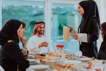  Muslim family having Iftar dinner drinking water to break feast. Eating traditional food during Ramadan feasting month at home. The Islamic Halal Eating and Drinking in modern home 
