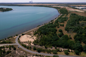 bicycle road in nature in the middle of the forest and lake seen from above from the drone