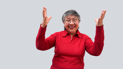 Mujer mayor latina con lentes sonriendo y alzando las manos