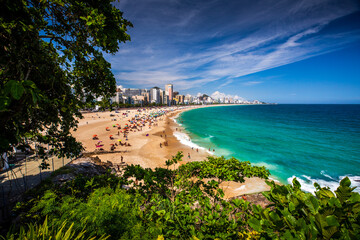 Beachgoers in Rio de Janeiro, Brazil play on the sand and in the water of the Atlantic Ocean at Leblon Beach, near Ipanema and Copacabana.