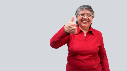 Mujer mayor latina sonriendo con el pulgar arriba 