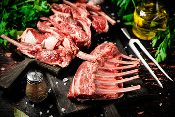 Raw rack of lamb with parsley on a cutting board. 