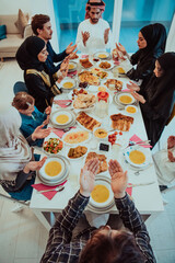 Top view of Muslim family having Iftar dinner drinking water to break feast. Eating traditional food during Ramadan feasting month at home. The Islamic Halal Eating and Drinking in modern home 