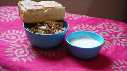 Spicy Misal Pav or usal Pav is a traditional and popular snack or Chat food from Maharashtra, India. Served with chopped onion, lemon wedges and farsan.Selective focus with copy space