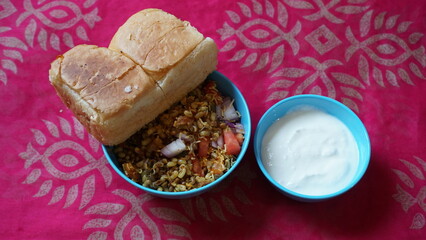 Spicy Misal Pav or usal Pav is a traditional and popular snack or Chat food from Maharashtra, India. Served with chopped onion, lemon wedges and farsan.Selective focus with copy space