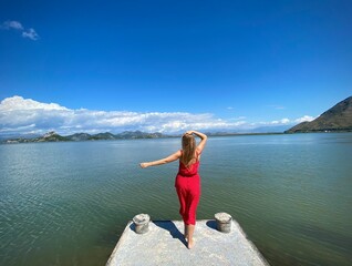 Young girl in a trendy red clothes enjoying the beauty of nature, relaxing, adventure, amazing nature, tour agency concept, meditating