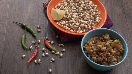 Sprouted matki or moth bean which is rich in protein and vitamins in plate with lemon and chilly.