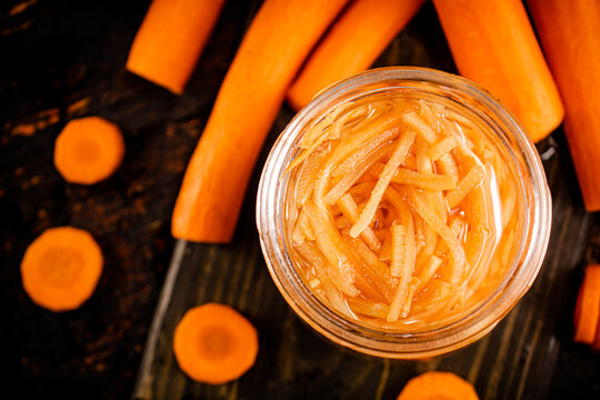 Canned Carrots In A Jar On A Cutting Board. 